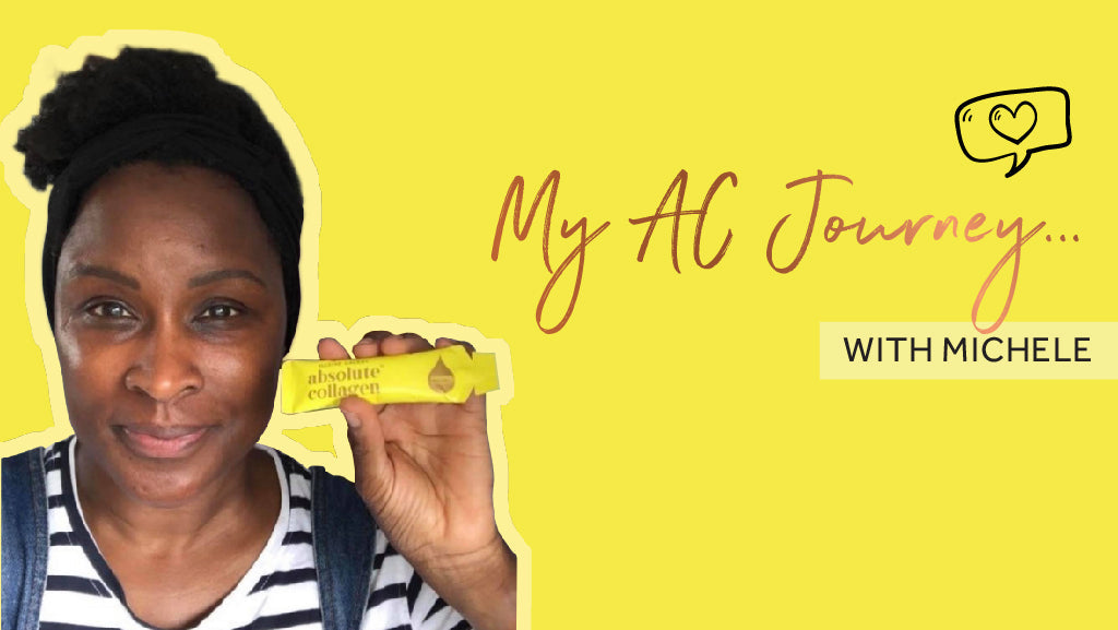 Photo of a smiling Black woman with an Afro tied back with a dark scarf, she is wearing a stripy top and holding a yellow sachet of Absolute Collagen to the camera