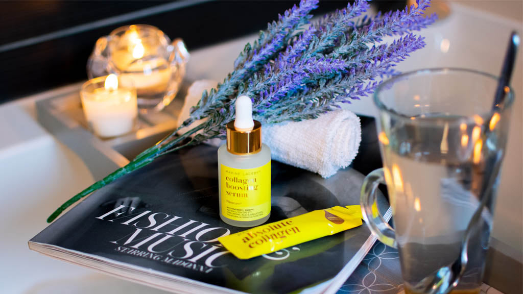 Photo showing a bath with candles, lavender, a magazine, Absolute Collagen sachet and Maxerum bottle